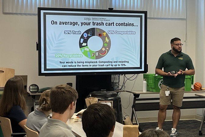 Instructor teaching a class of students about waste in the City in a classroom