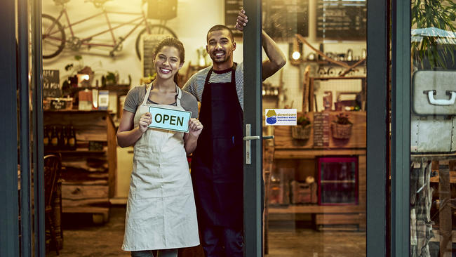 Business owners holding open sign