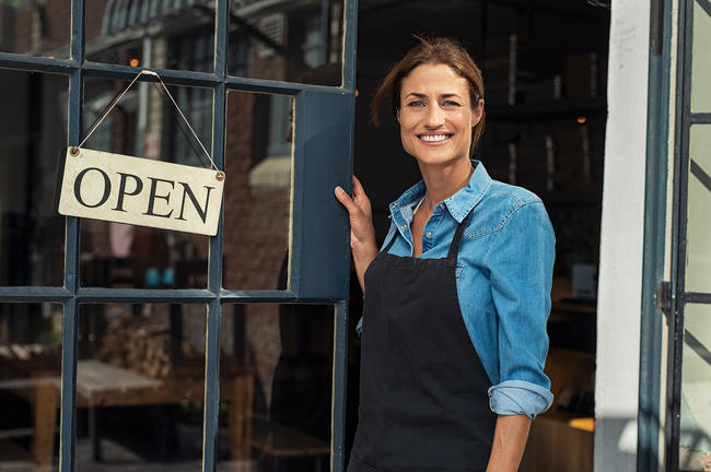 Woman standing next to open sign